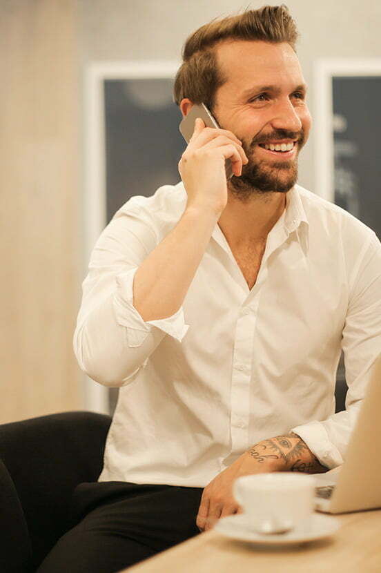 man die lachend belt met zijn mobiele telefoon